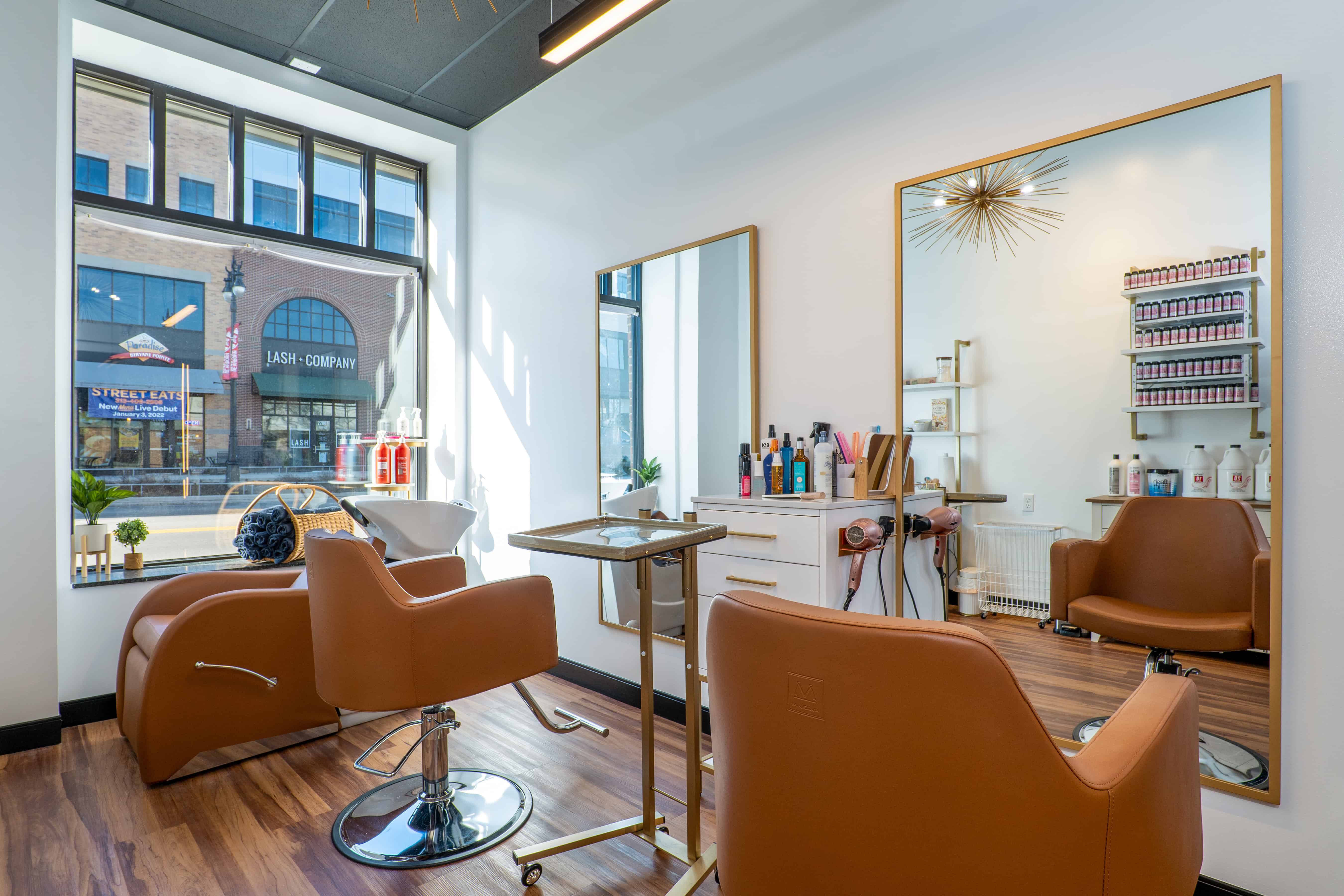 Private Cosmo Salon Studios suite with brown styling chairs looking out a sunlit window
